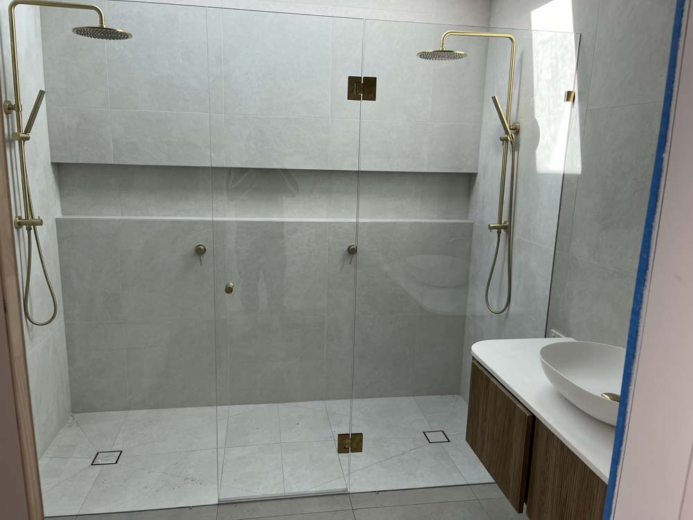 Frameless Shower Screen with brushed brass hardware installed in Fingal